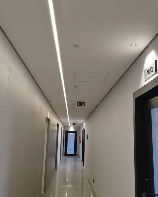 Perfil de LED em corredor: Iluminação linear embutida no forro.